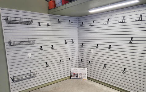 Trusscore gray slatwall installed in basement with slatwall accessories