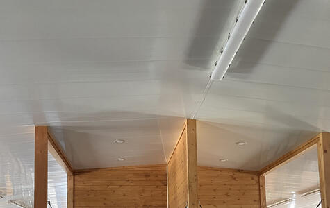 Trusscore white wallandceilingboard installed on the ceiling and walls for a horse stable
