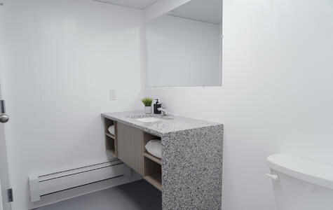 Trusscore white wall&ceilingboard installed vertically on bathroom walls in multi-residential facility